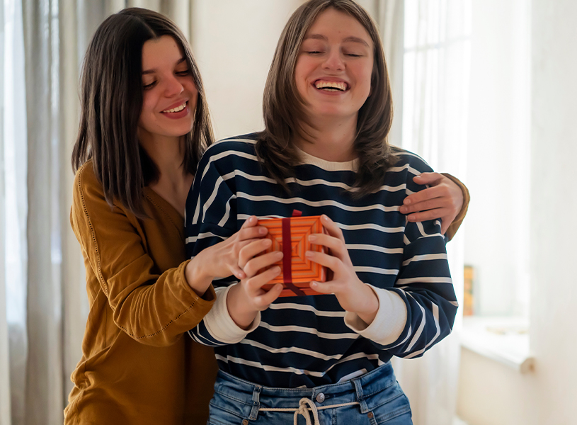 Die Schwester schenkt ein Geschenk zum Geburtstag